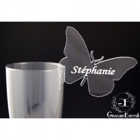 Un verre décoré avec ce marque place personnalisé avec le prénoms de vos invités, et découpé enforme de Papillon.