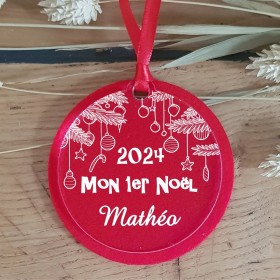 Une décoration fabriquée en Feutrine rouge et personnalisé sur du plexi transparent avec l'année du 1er Noël et le prénom.