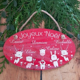 Une décoration de Noël en bois, à accrocher, avec de personnalisé le prénom de toute la famille.